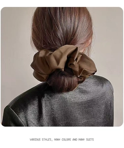 Brown large satin scrunchie hair tie shown on a low bun hairstyle in back view