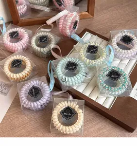 Vue détaillée d'élastiques spirales à fleurs dans des boîtes cadeaux transparentes