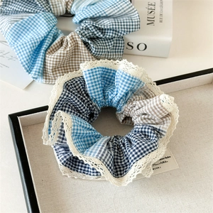 Detail shot of oversized plaid scrunchies with lace trim and soft fabric texture