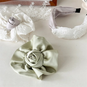 Vue détaillée de la rose en satin vert clair et accessoires de cheveux en dentelle