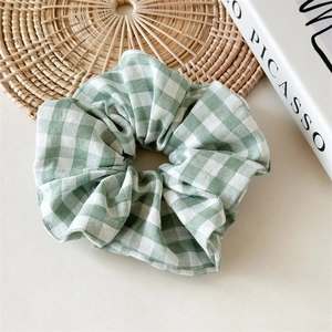 Détail d'un chouchou à carreaux vichy vert et blanc avec texture douce en coton lin