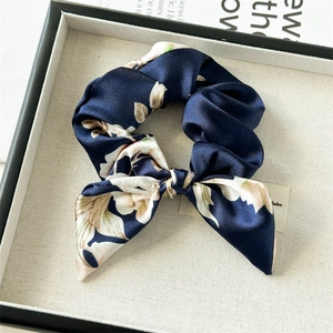 Detail of blue floral satin scrunchie with long ribbon bow in a black gift box