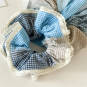 Detail of blue and brown checkered hair scrunchies with elegant white lace borders