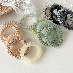 Vue à plat d'élastiques à cheveux spirale colorés avec motifs à carreaux et floraux