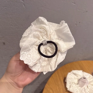 Gros plan sur un chouchou élégant en dentelle blanche avec élastique noir