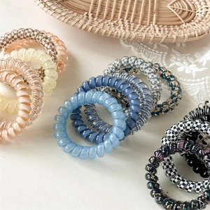 Détail d'élastiques à cheveux spirale en couleurs pastel et motifs à carreaux
