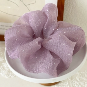 Détail d'un chouchou en tulle lavande avec paillettes argentées au style sophistiqué