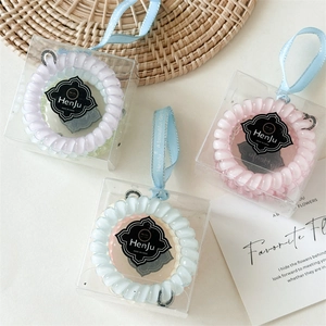 Détail d'élastiques spirales pastel en boîtes individuelles avec poignées en ruban