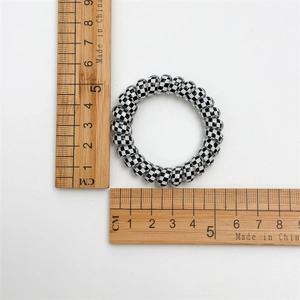 Détail de l'élastique spirale à motif damier noir et blanc avec mesure de 5,5 cm