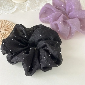 Détail de chouchous en organza crème avec strass argentés brillants en noir et lavande