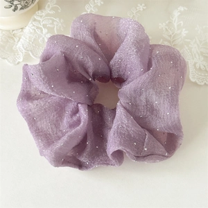 Détail du chouchou en maille lilas avec strass étincelants et volants élégants et raffinés
