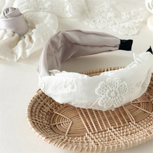 Détail du bandeau élégant en dentelle florale crème avec doublure en satin et broderie