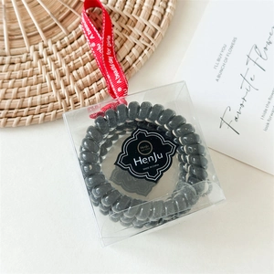 Trois élastiques à cheveux spirales noirs dans un coffret cadeau avec ruban