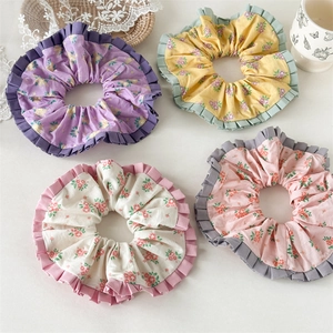 Set mit vier floralen XL-Haargummis in den Farben Pastelllila, Gelb, Cremeweiß und Rosa