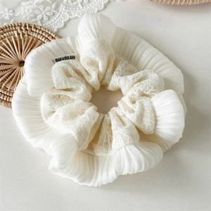 Vue détaillée du chouchou en dentelle crème avec broderie florale élégante