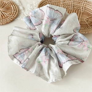 Détails de chouchou en maille blanche avec motifs papillons et paillettes fines