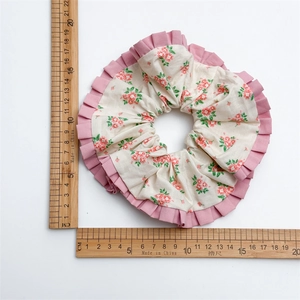 Übergroßes Haargummi mit Blumenmuster, rosa Rüschenkanten und cremefarbenem Stoff