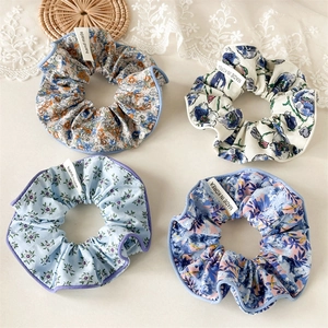 Détail de quatre chouchous floraux avec étiquettes faites main et bordures violettes