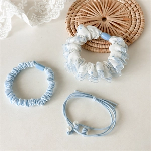 Detail van lichtblauwe haarstrikken set met kanten rand en elastieken met parels
