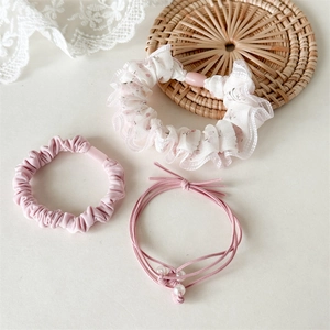 Detail van roze bloemen scrunchie en elastische haarbanden met parels op wit kant decor