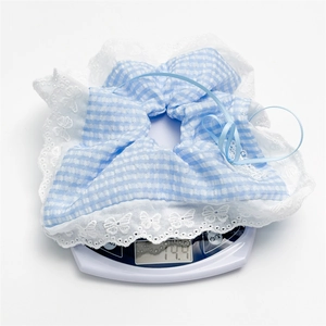 Detail showing blue gingham scrunchie with lace edge being weighed on digital scale