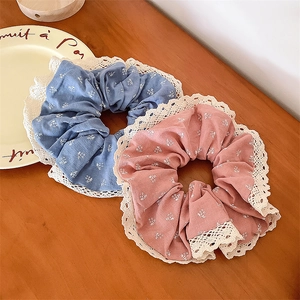 Gros plan de chouchous à fleurs bleu et rose avec dentelle blanche sur bois