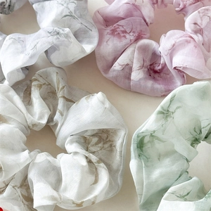 Close-up of ink wash floral chiffon scrunchies with pleated texture and soft pastel colors