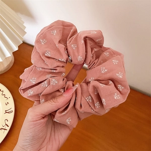 Gros plan du chouchou rose à fleurs avec bords en dentelle et motif floral délicat