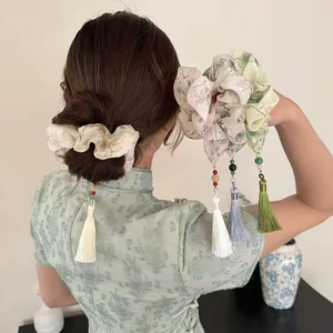 Detail view of a Chinese ink style floral scrunchie with long elegant silk tassels