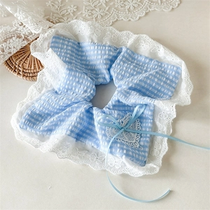 Detail of blue plaid scrunchie with white lace edges, heart pendant and ribbon bow