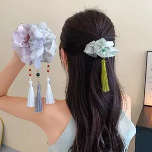 Detail of floral scrunchie with tassel and beads on organza fabric in New Chinese style
