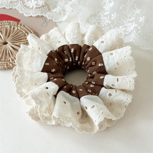 Detail of vintage floral hair scrunchie with beige embroidery lace and retro patterns