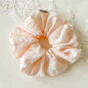 Nahaufnahme von rosa Blumen-Haargummi mit weichem Bubble-Stoff und kleinen weißen Blumen