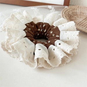 Detailed macro of vintage two-tone embroidered lace scrunchie with floral fabric pattern
