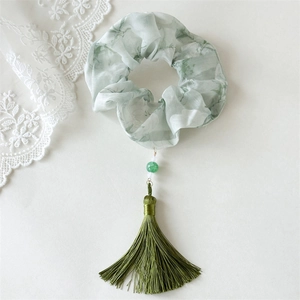 Detail of floral scrunchie with green beads and long tassels in elegant Chinese style