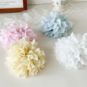 Détail de chouchous fleurs en dentelle aux tons pastel rose, bleu, jaune et blanc élégants