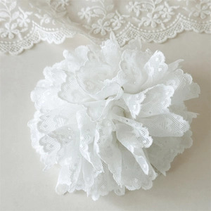 Détail d'un accessoire floral en dentelle blanche élégante avec des couches délicates