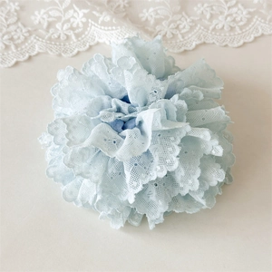 Détail d'un chouchou en dentelle bleu clair avec broderie multicouche et texture