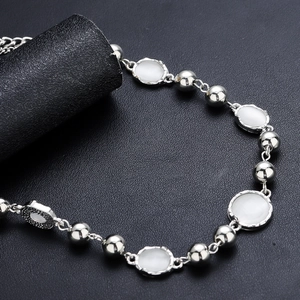 Collier en pierre de lune et perles argentées avec fermoir sur fond noir élégant