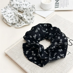 Gros plan de chouchous à fleurs noir et blanc avec une élégante texture de tissu plissé