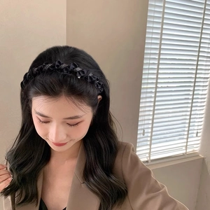 Detail of elegant black pleated headband with silver rhinestones on a female model