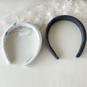Detail of blue bow fabric headbands with stripe pattern in white and dark grey colors