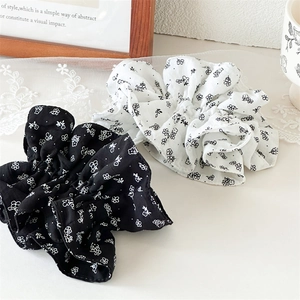 Détail de chouchous en coton à fleurs noir et blanc sur un fond de dentelle élégante
