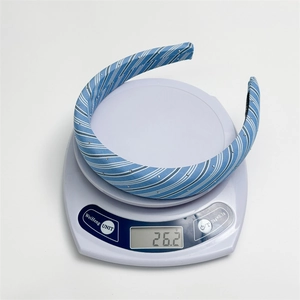 Detail view of light blue checkered headband with small metal studs on a digital scale