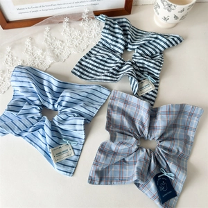 Close-up of handmade blue plaid and striped cotton hair scrunchies on a white surface