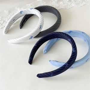 Detailed view of handmade fabric headbands with blue bow patterns in four colors
