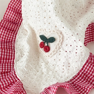 Macro detail of pastoral lace hair kerchief with cherry heart embroidery and red gingham trim