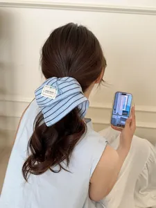 Detailed back view of a blue striped scrunchie with handmade bow on tied hair