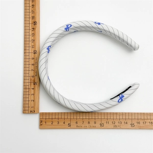 Blue bow print fabric headband with diagonal stripes for women on a white background