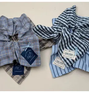 Detail showing oversized plaid and striped fabric bow scrunchies with handmade labels